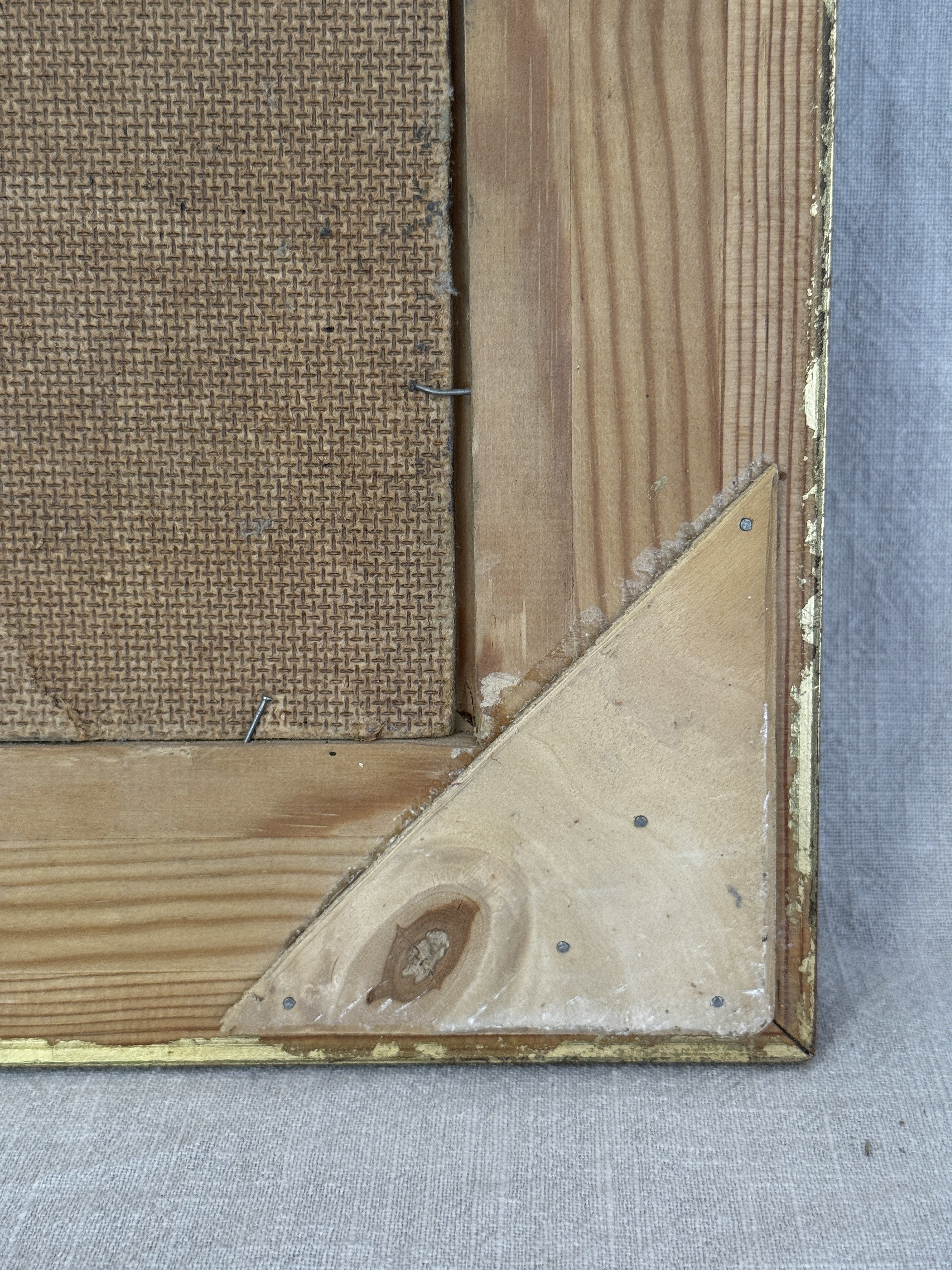 Corner detail of the frame reverse with triangular blocks and worn gilding on the vintage Swedish painting