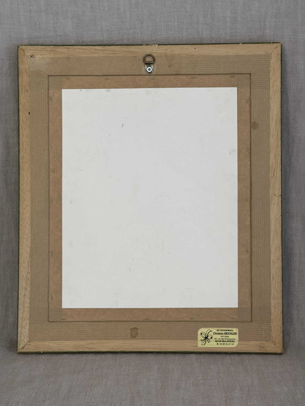 Reverse of the French oil painting with backing board, hanging fitting and the Mulhouse framer's label