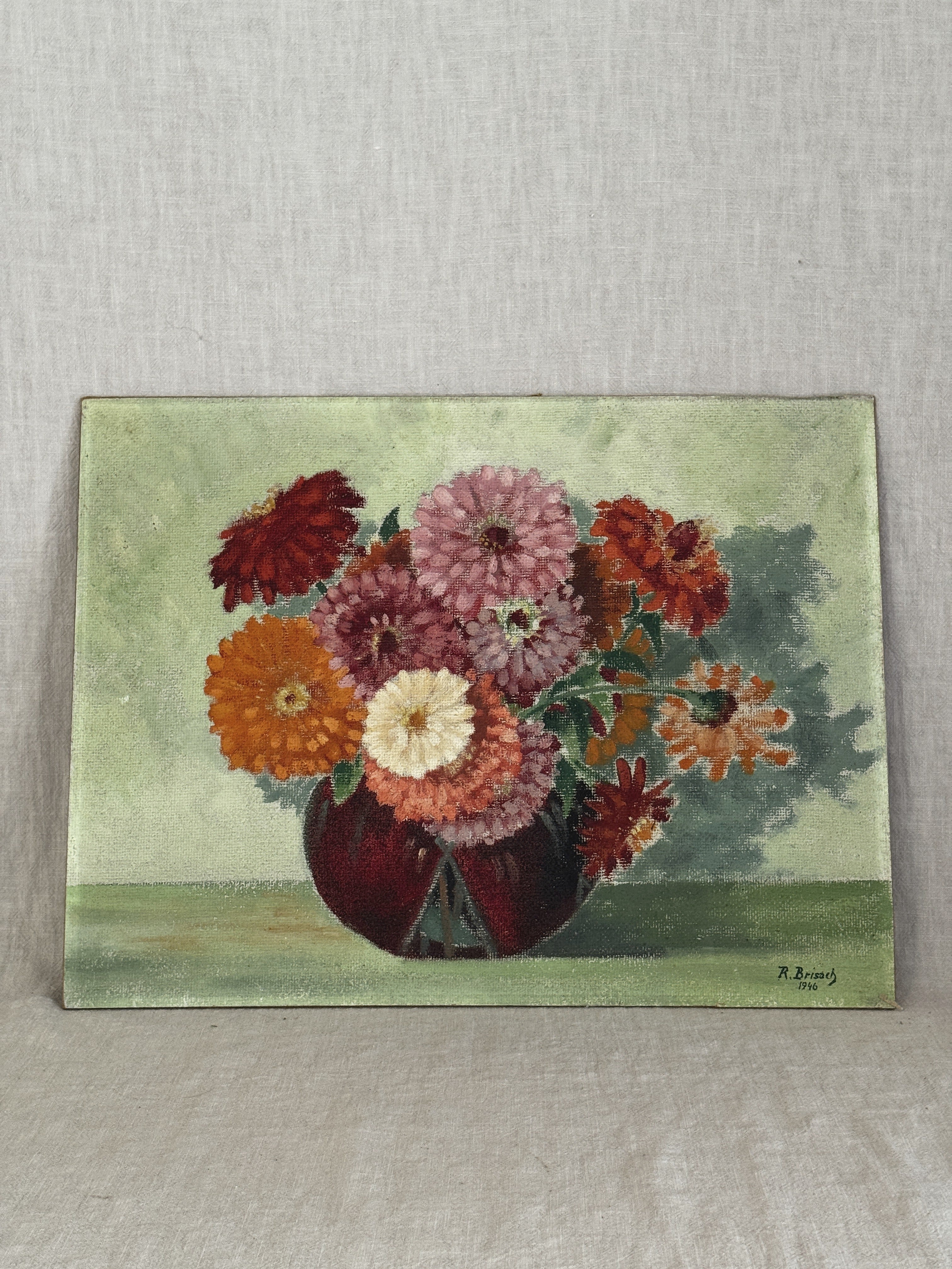 Unframed French oil painting of a zinnia and dahlia bouquet in a dark red vase, dated 1946