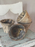 Four antique French terracotta resin pots with dark pine resin patina, grouped on a painted stool