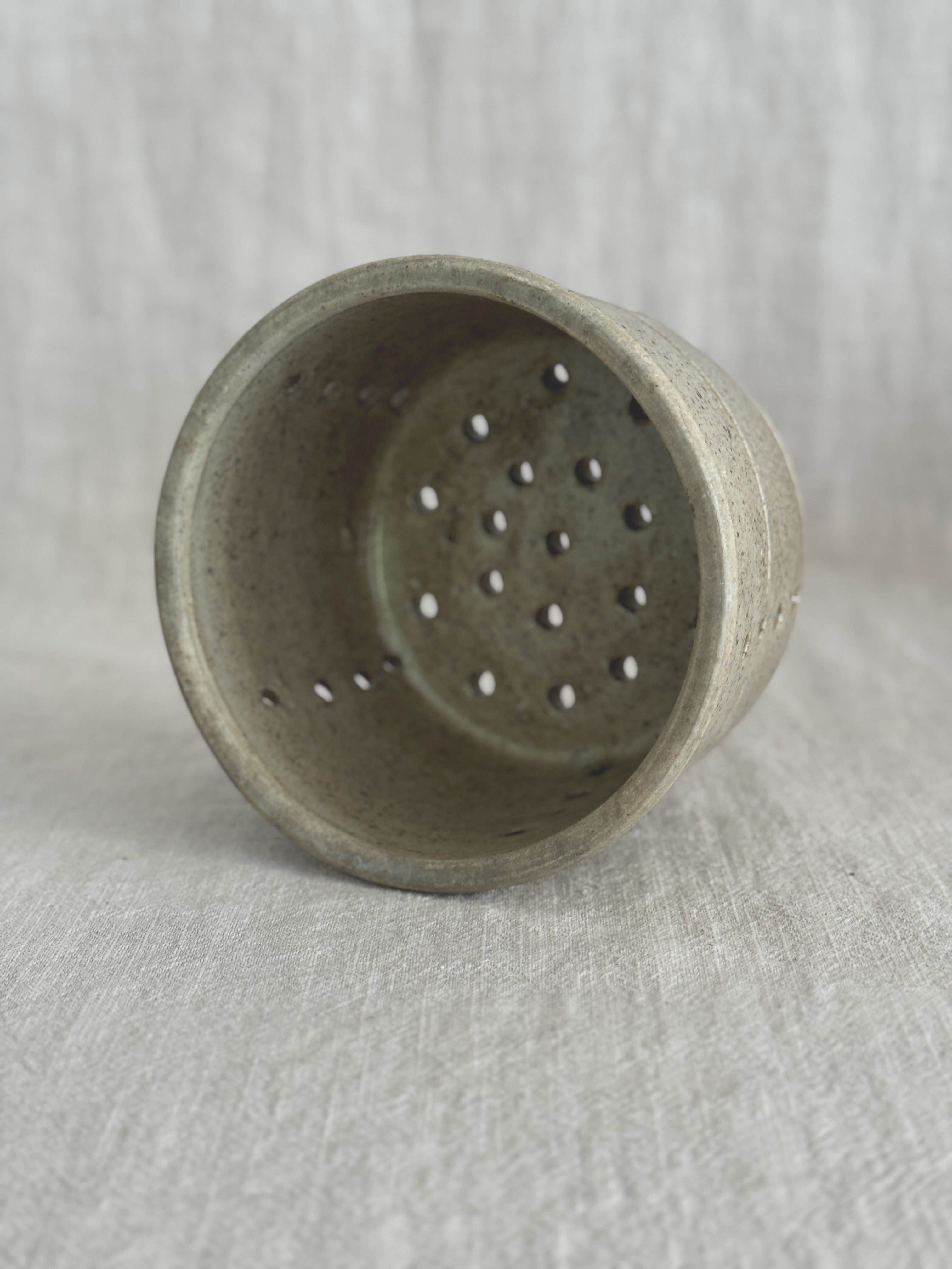 Looking into the French faisselle, showing the pierced base and hand-cut drainage holes