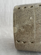 Close-up of the faisselle wall showing a small worn impressed mark, an incised turning line and drilled holes