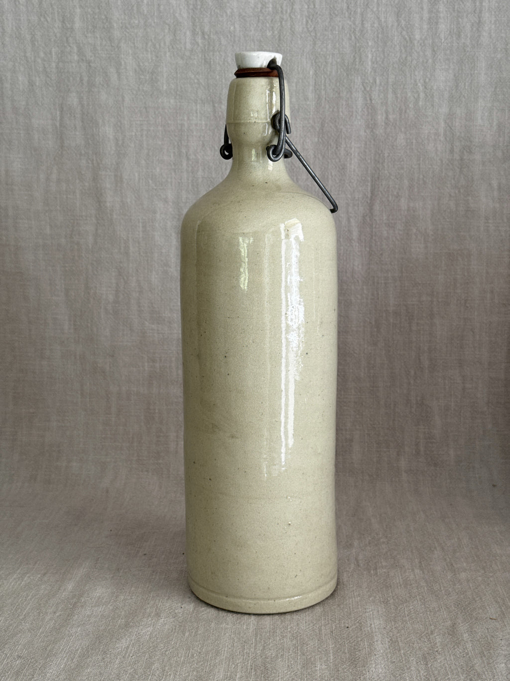Cream-glazed stoneware bail-top bottle with wire closure and porcelain stopper