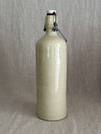 Cream-glazed stoneware bail-top bottle with wire closure and porcelain stopper