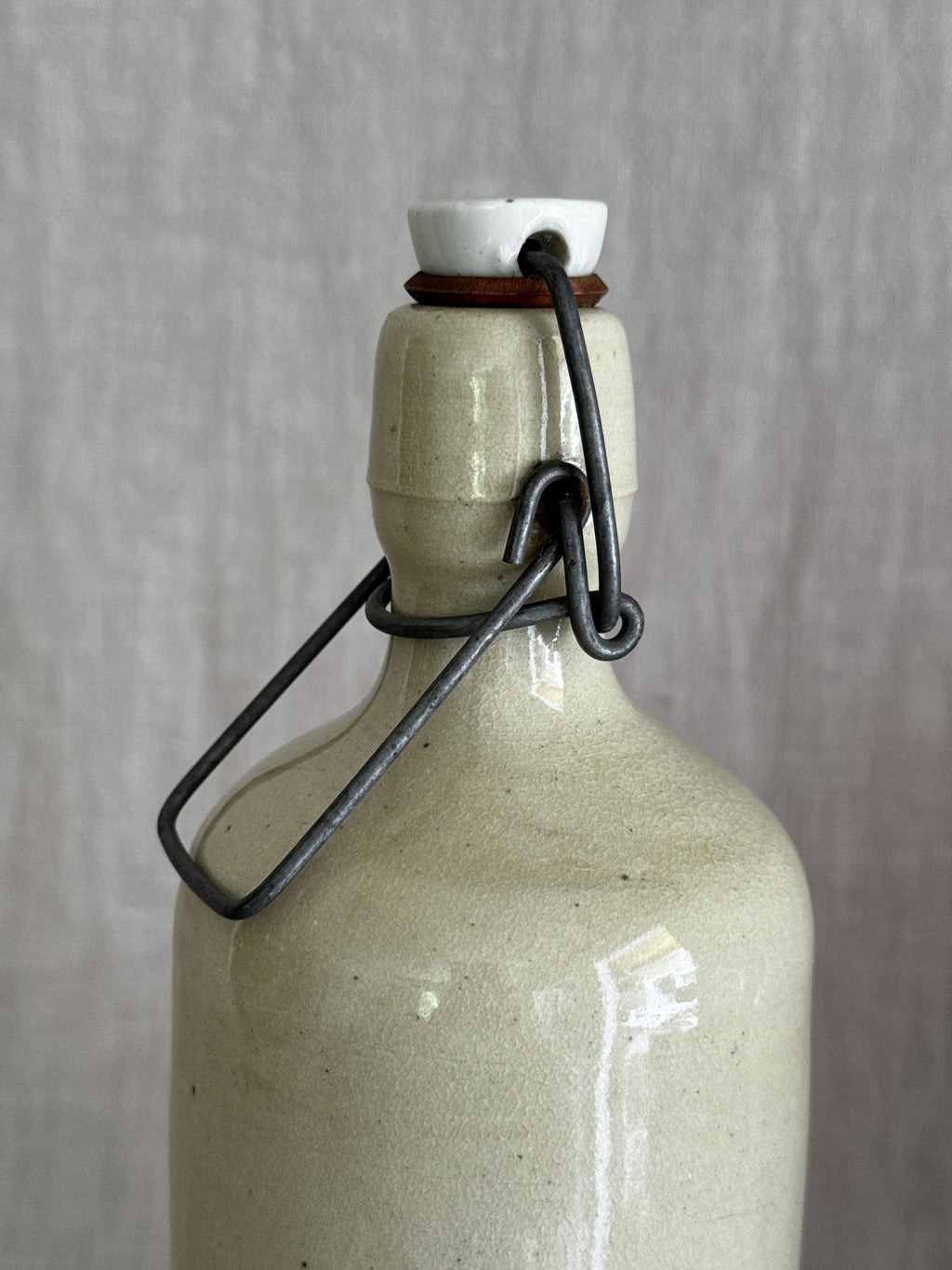 Shoulder and double-ridged collar of the cream stoneware bottle