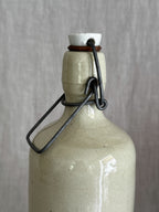 Shoulder and double-ridged collar of the cream stoneware bottle