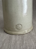 Worn round pottery stamp impressed low on the body of the French stoneware bottle