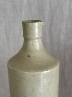 Close view of the bottle's sloping shoulder and short collar with its hand-pinched pouring lip