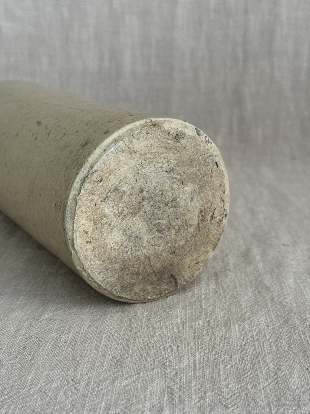 The French stoneware bottle laid on its side, showing the unglazed buff clay base