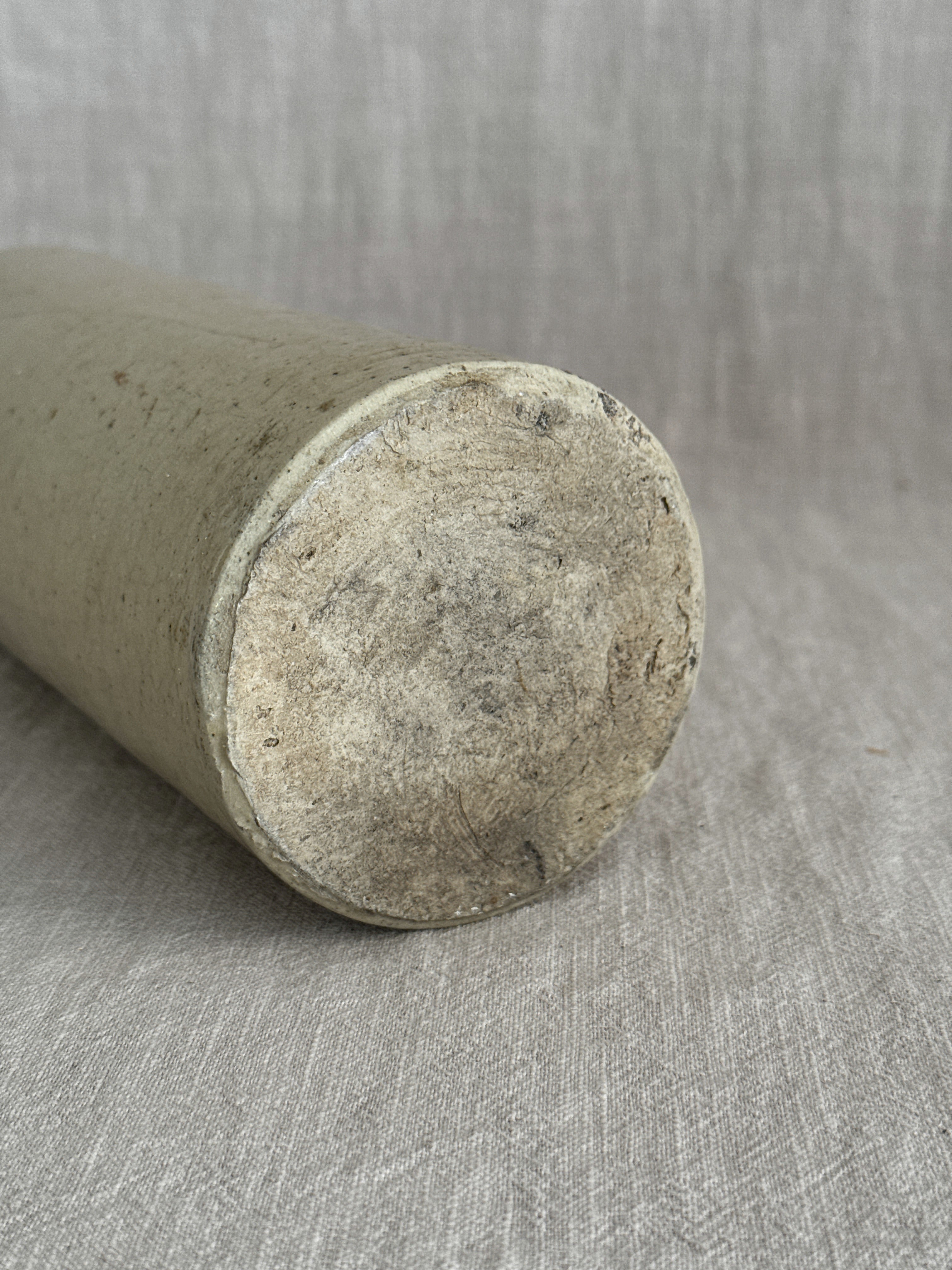 The French stoneware bottle laid on its side, showing the unglazed buff clay base