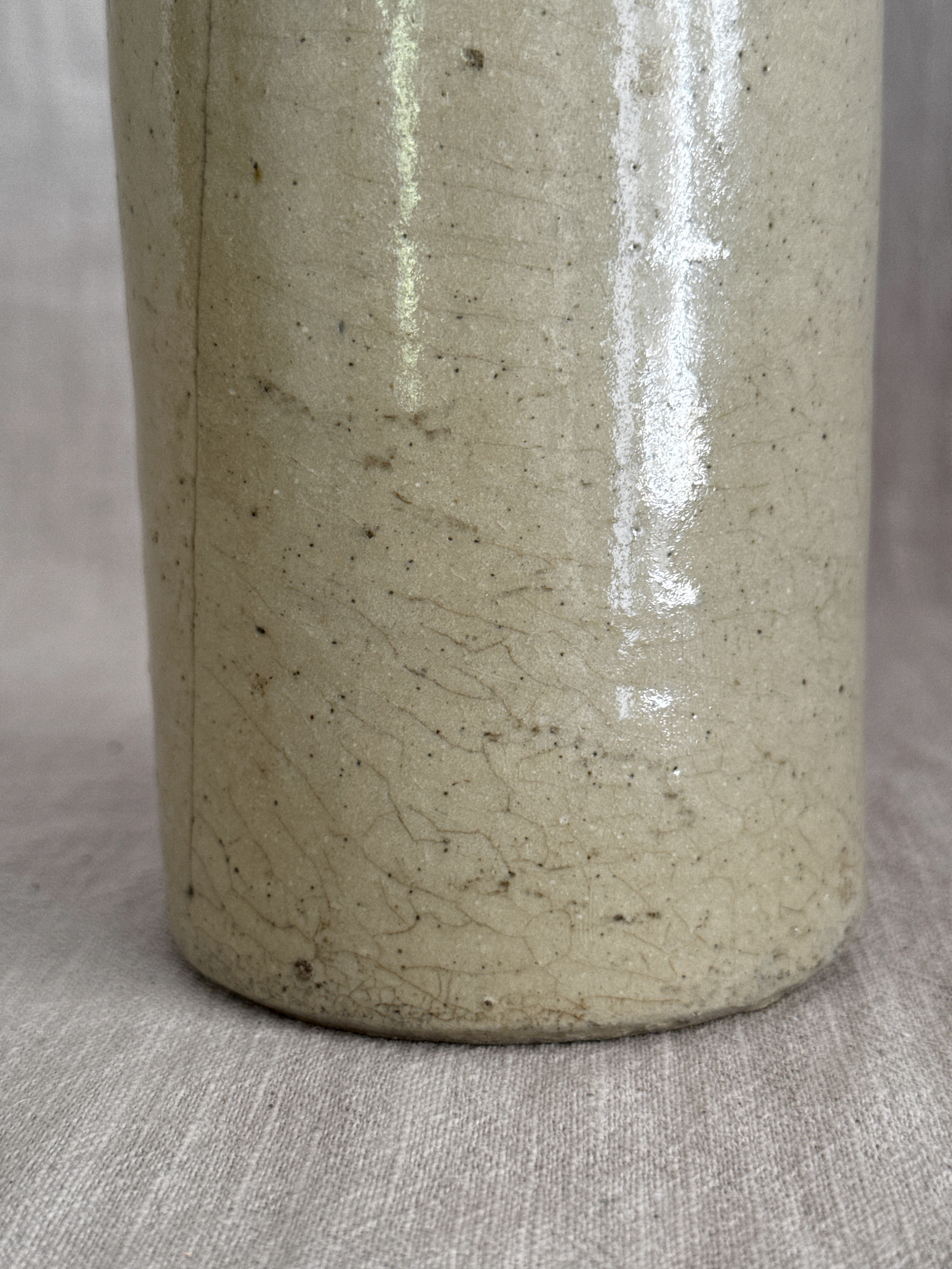 Close view of the lower body, where the fine even crazing across the cream glaze is clearest