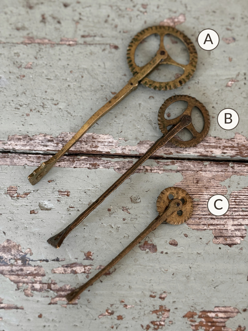 Three antique brass pastry jaggers marked A, B and C