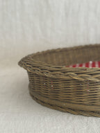 Close-up of the braided willow rim and close-woven sides of a vintage oval basket tray
