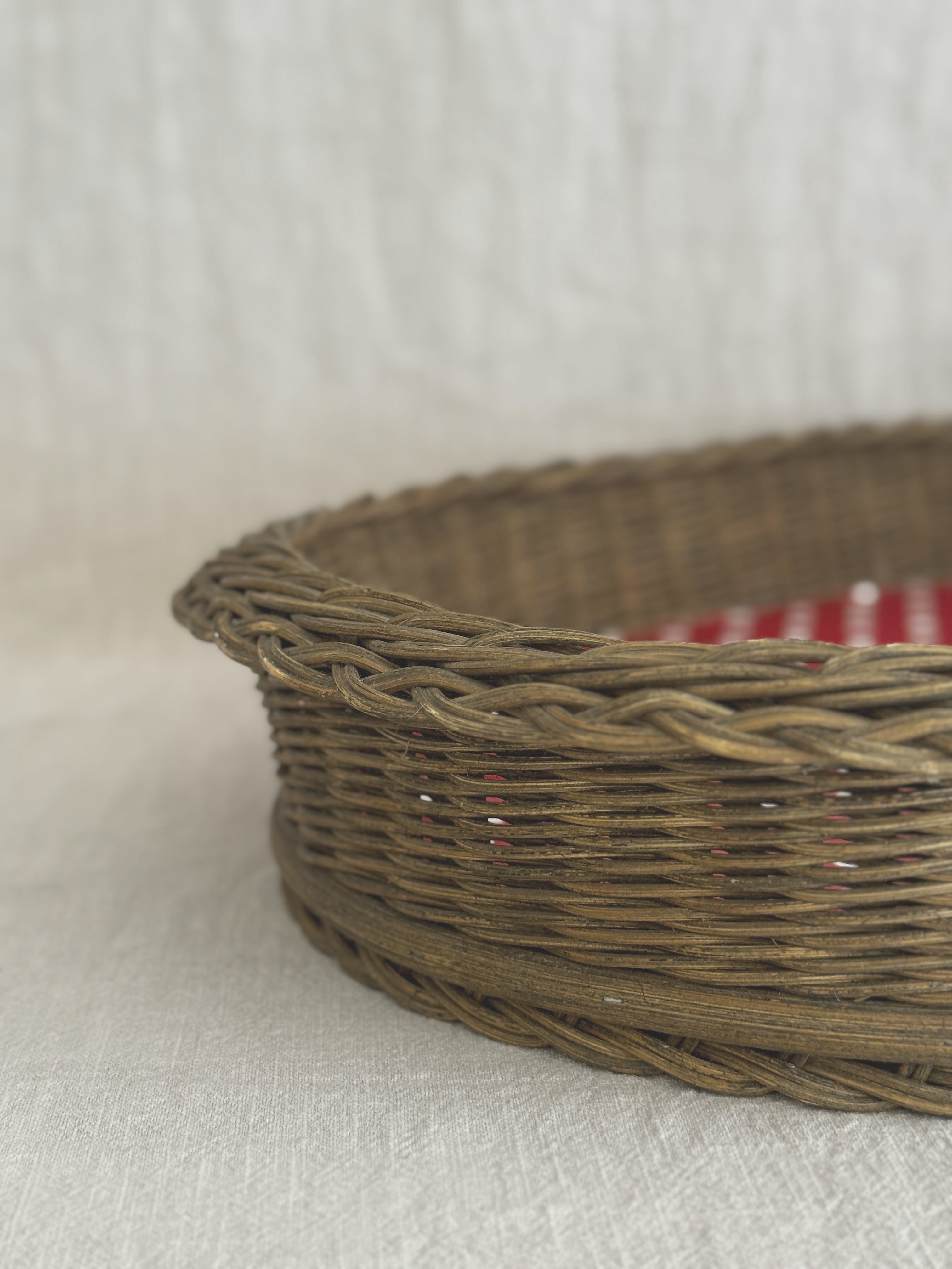 Close-up of the braided willow rim and close-woven sides of a vintage oval basket tray