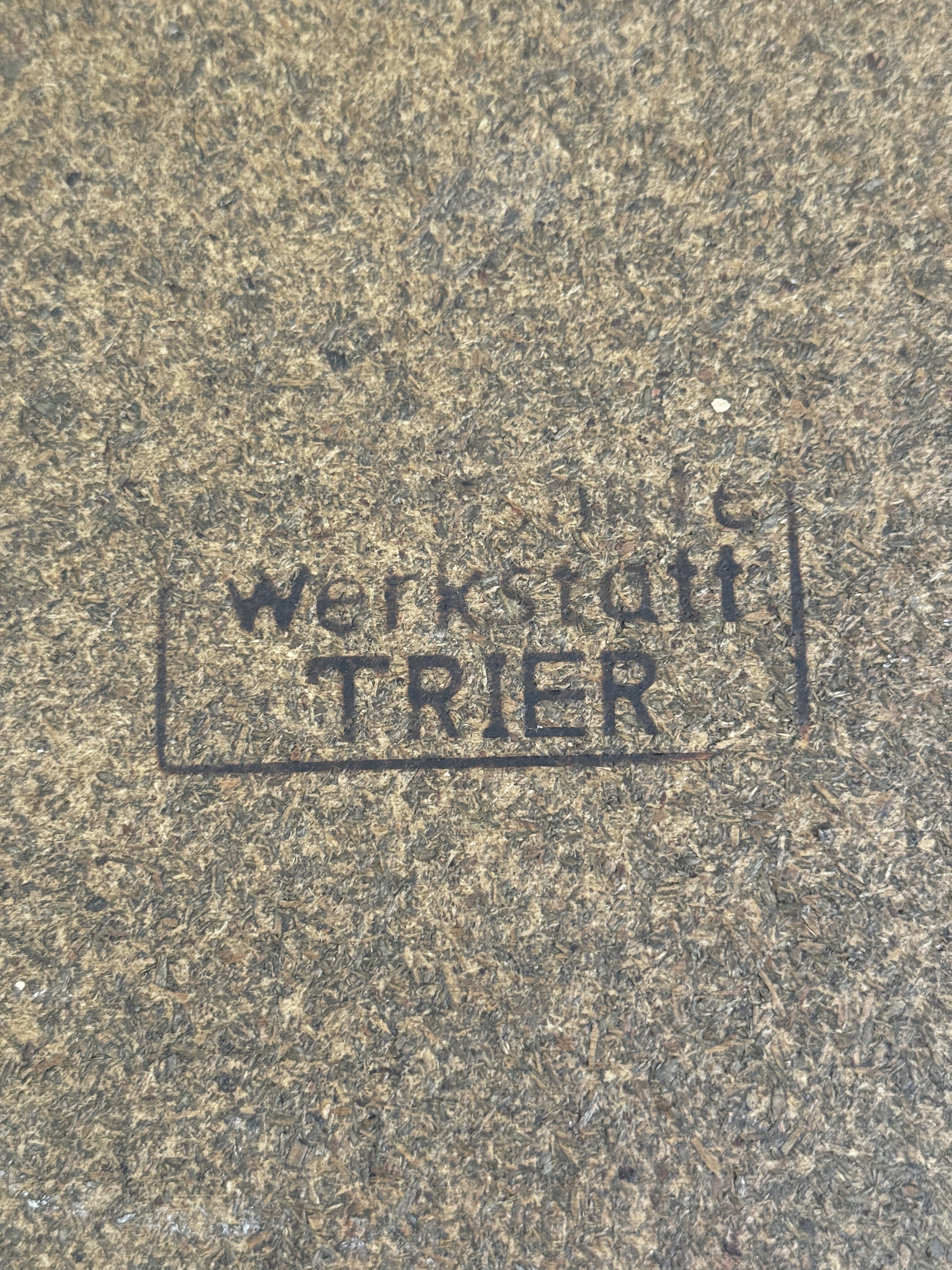 Faded rubber stamp on the fibreboard base reading werkstatt TRIER inside a rectangular frame