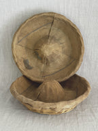 Two linen-lined bannetons, one propped upright, showing the staining and soft creases in the aged liner
