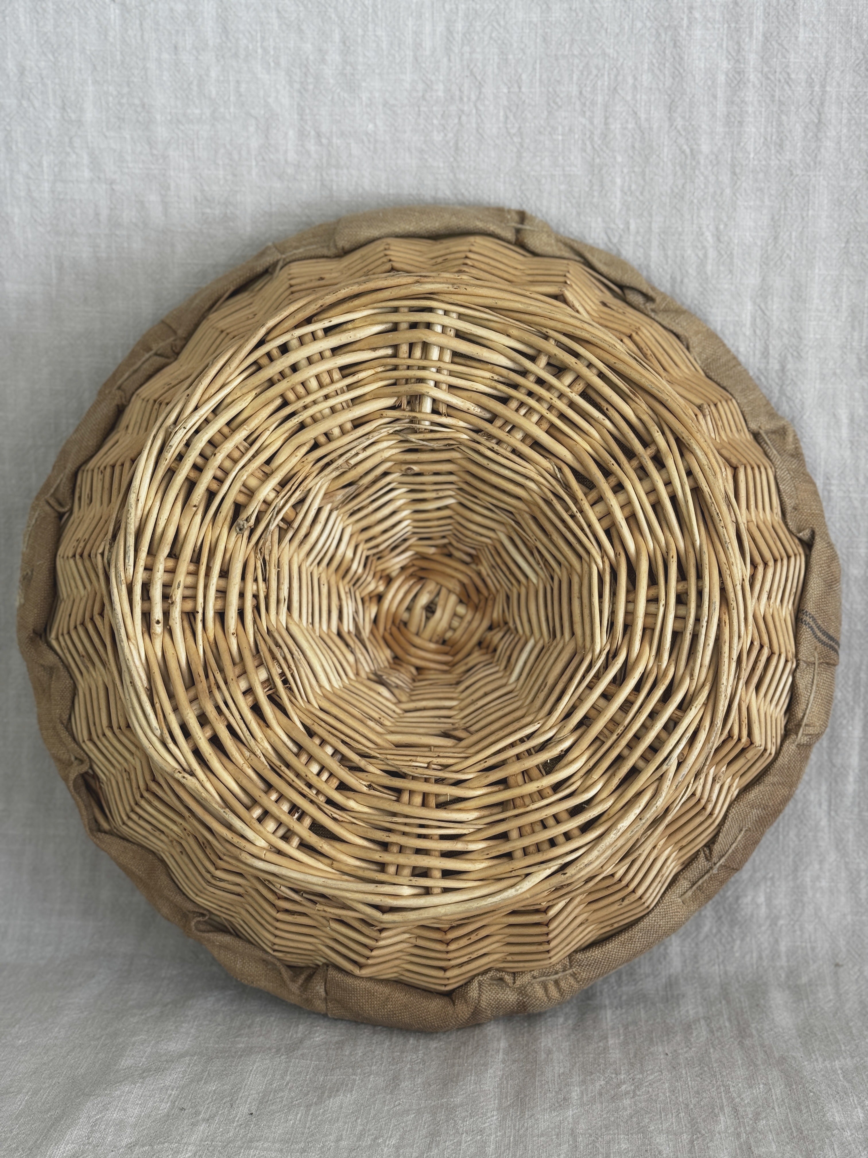 Base of a second willow banneton photographed from below, spiral weave and stapled linen rim