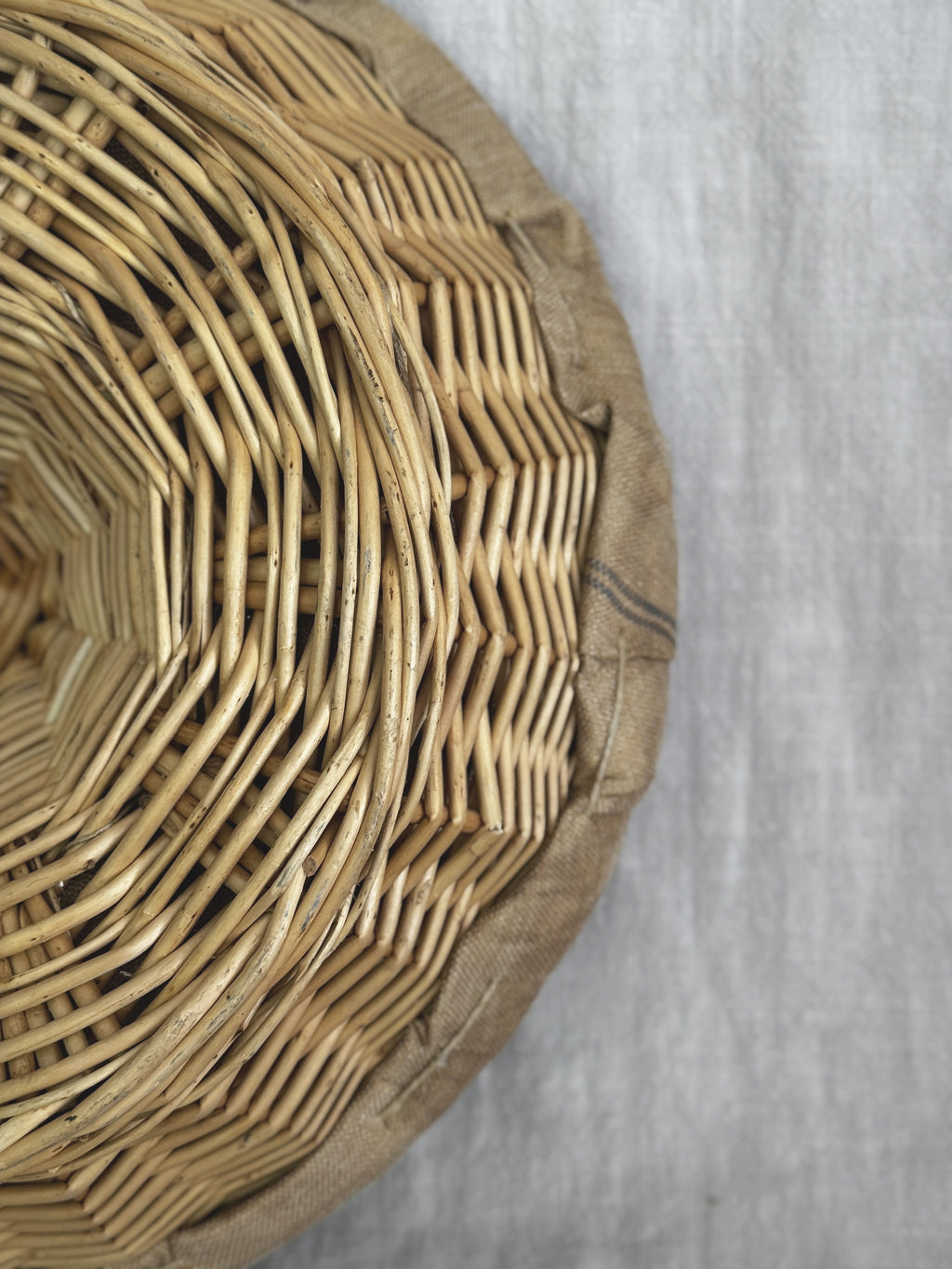Close-up of the willow weave and the linen edge at the rim of a French bread proofing basket