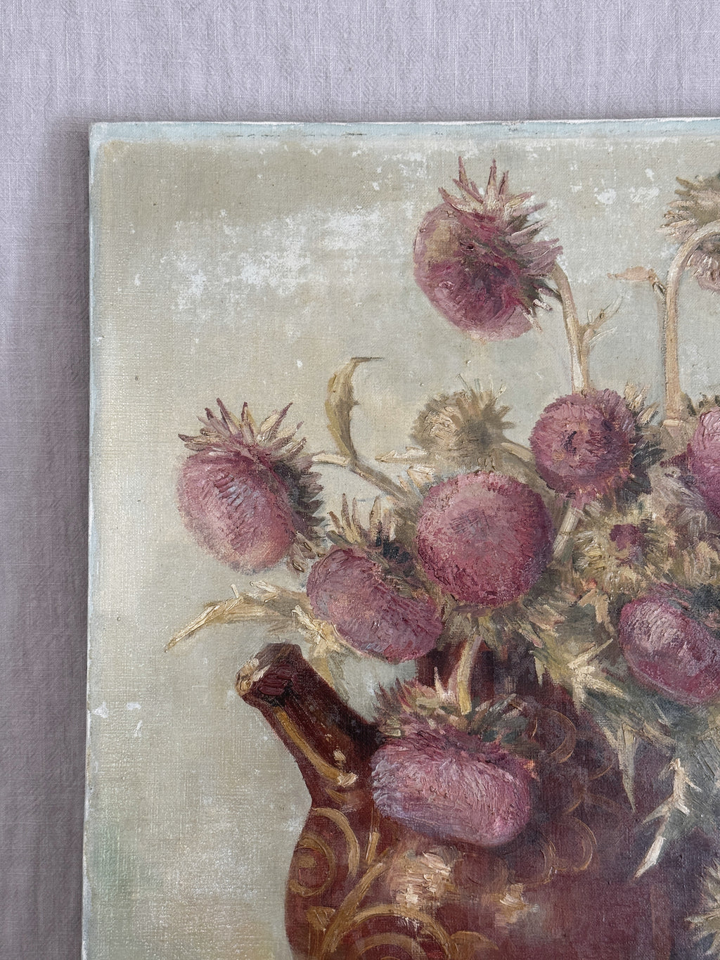 Detail of the upper left of the canvas showing thistle heads in dusty rose and straw yellow built up in short thick brushstrokes against a pale grey-green ground
