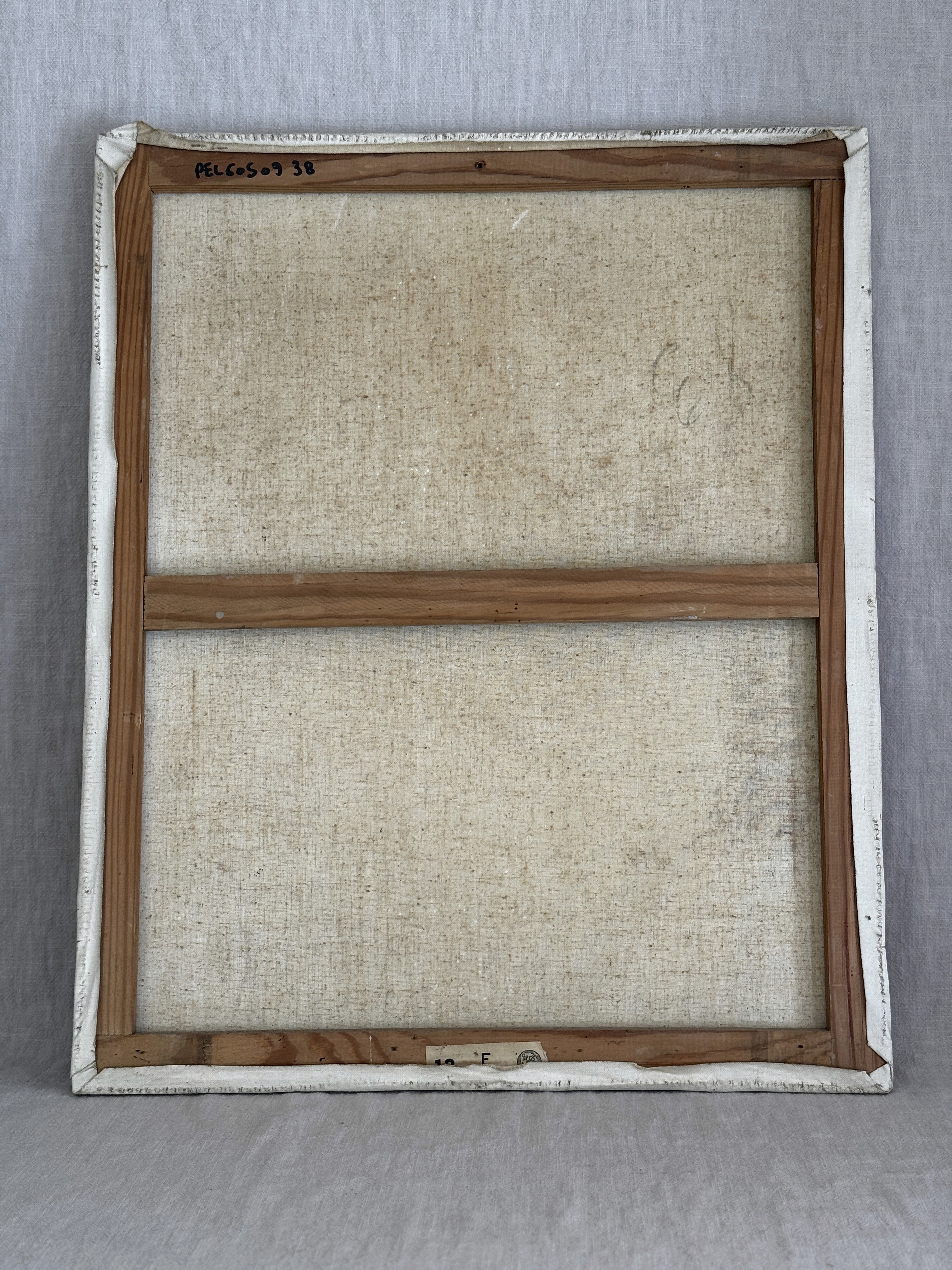 Reverse of the painting showing the light pine French stretcher, the original paper label marked 12 F and an inventory code written in black marker
