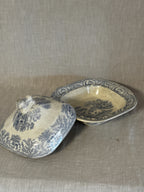 The covered dish with the lid lifted off, showing both halves of the blue transfer pattern
