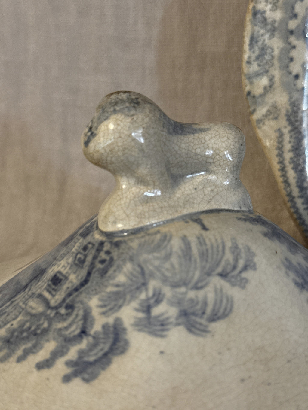 Close-up of the recumbent lion finial on the lid of the antique transferware dish