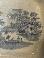 Detail of the blue transfer pattern showing palms, a pagoda and figures in a boat