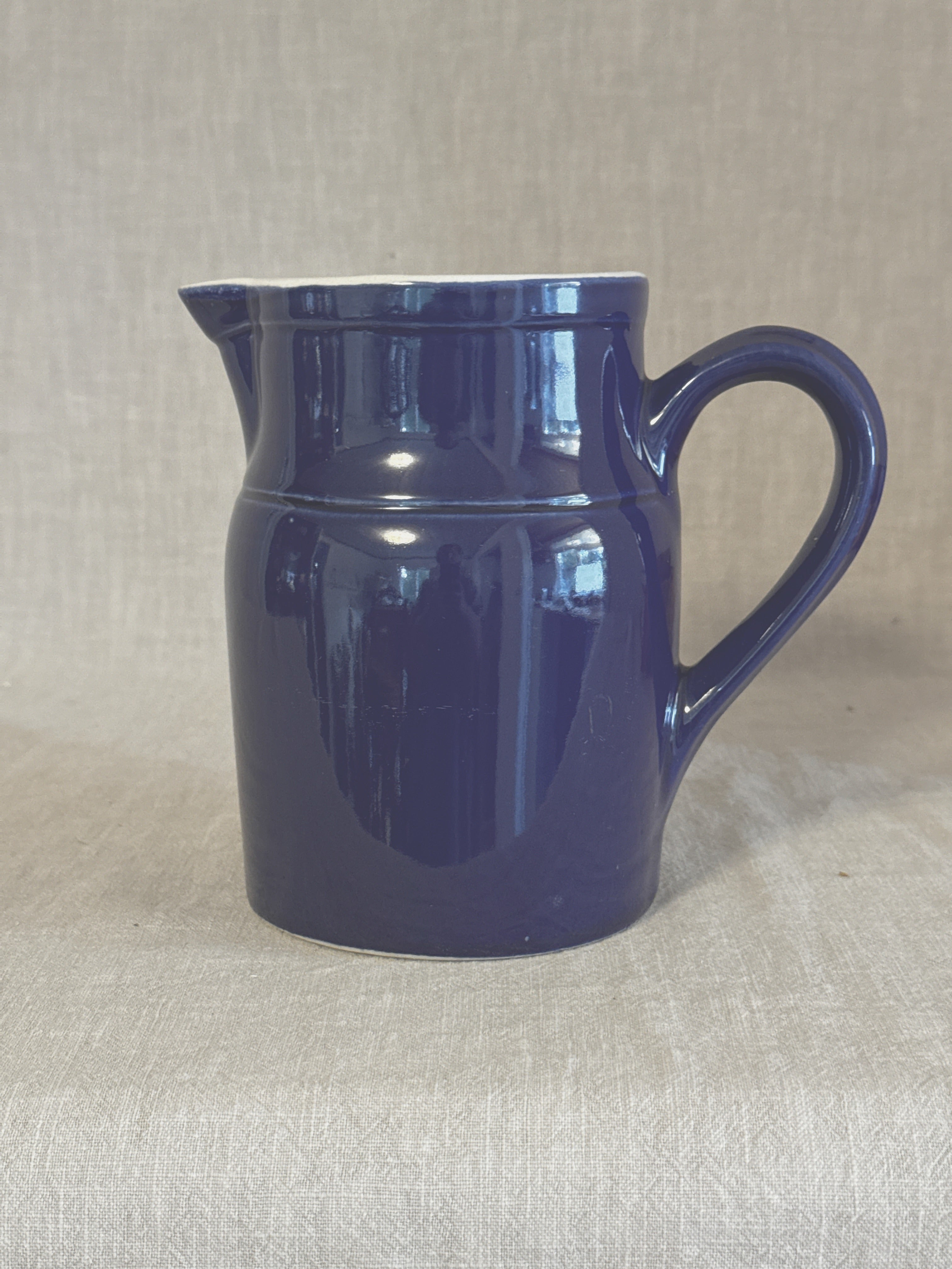 Side view of the blue Digoin stoneware pitcher showing the strap handle