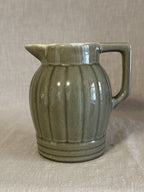 Ribbed jug in soft olive green glaze with a broad strap handle