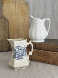 Pair of vintage English cream jugs, Crown Devon and Royal Crownford, shown together on antique books and a bread board for size reference