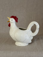 Side view of the rooster jug showing the sweeping tail that forms the handle