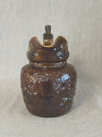 Front view of the treacle glazed relief jug showing the shaped spout and moulded neck