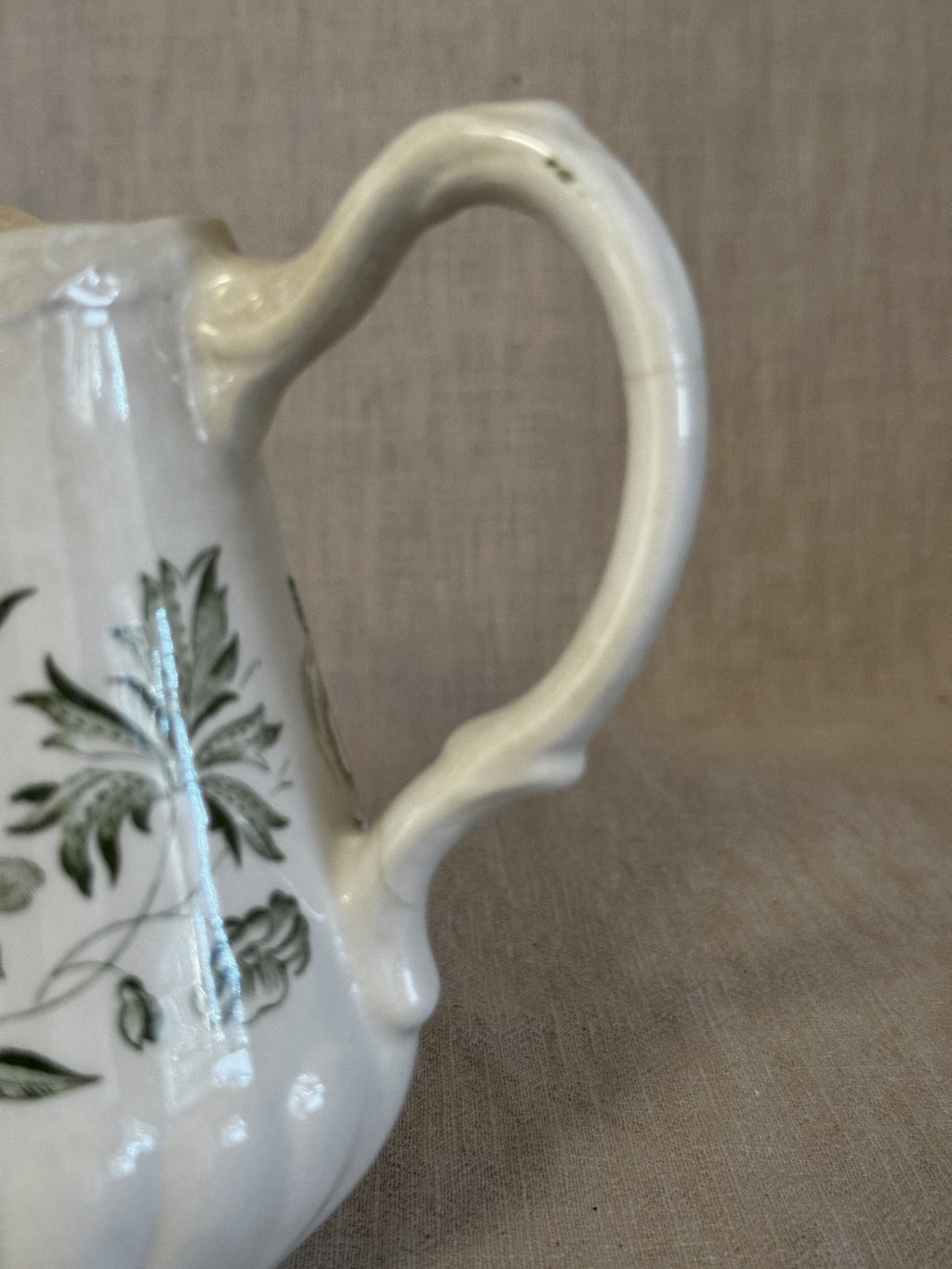 Detail of the handle and the warm staining that has settled into the cream ground