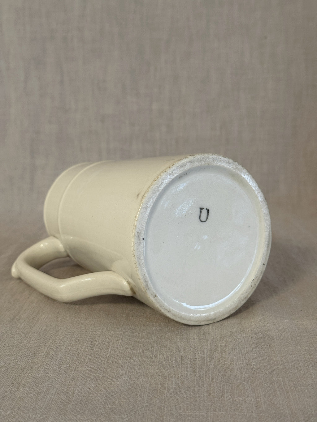 Base of the small white jug with a painted U size mark