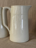 Detail of the tall white jug showing the spout and the plain glazed surface