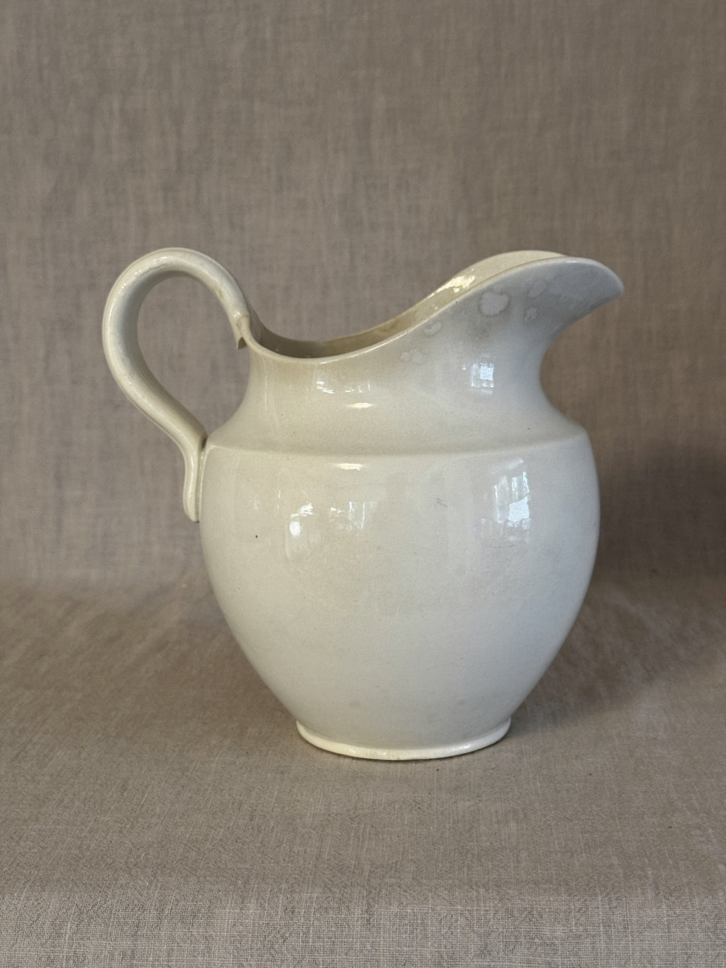 Three-quarter view of the white jug showing the full profile of the ewer form