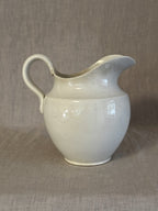 Three-quarter view of the white jug showing the full profile of the ewer form