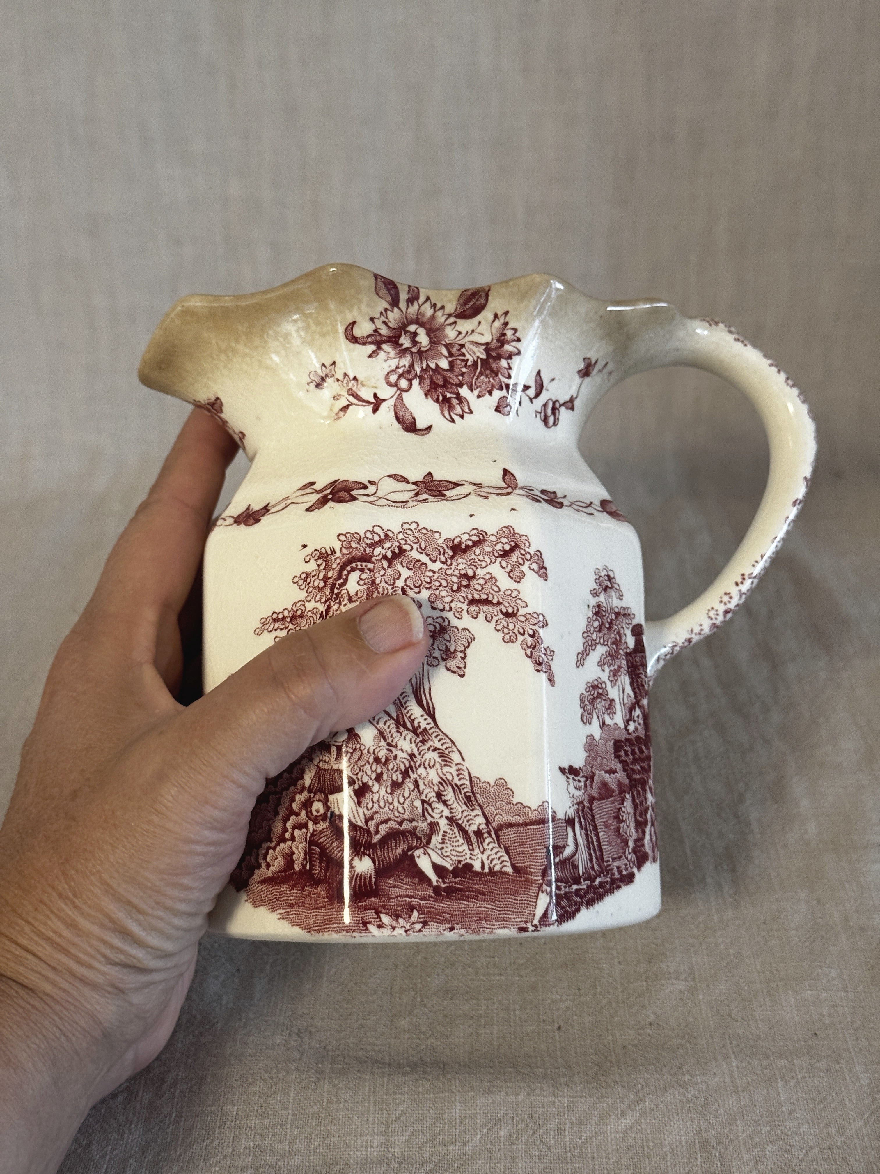 The Watteau jug held from the side, showing its size against a hand