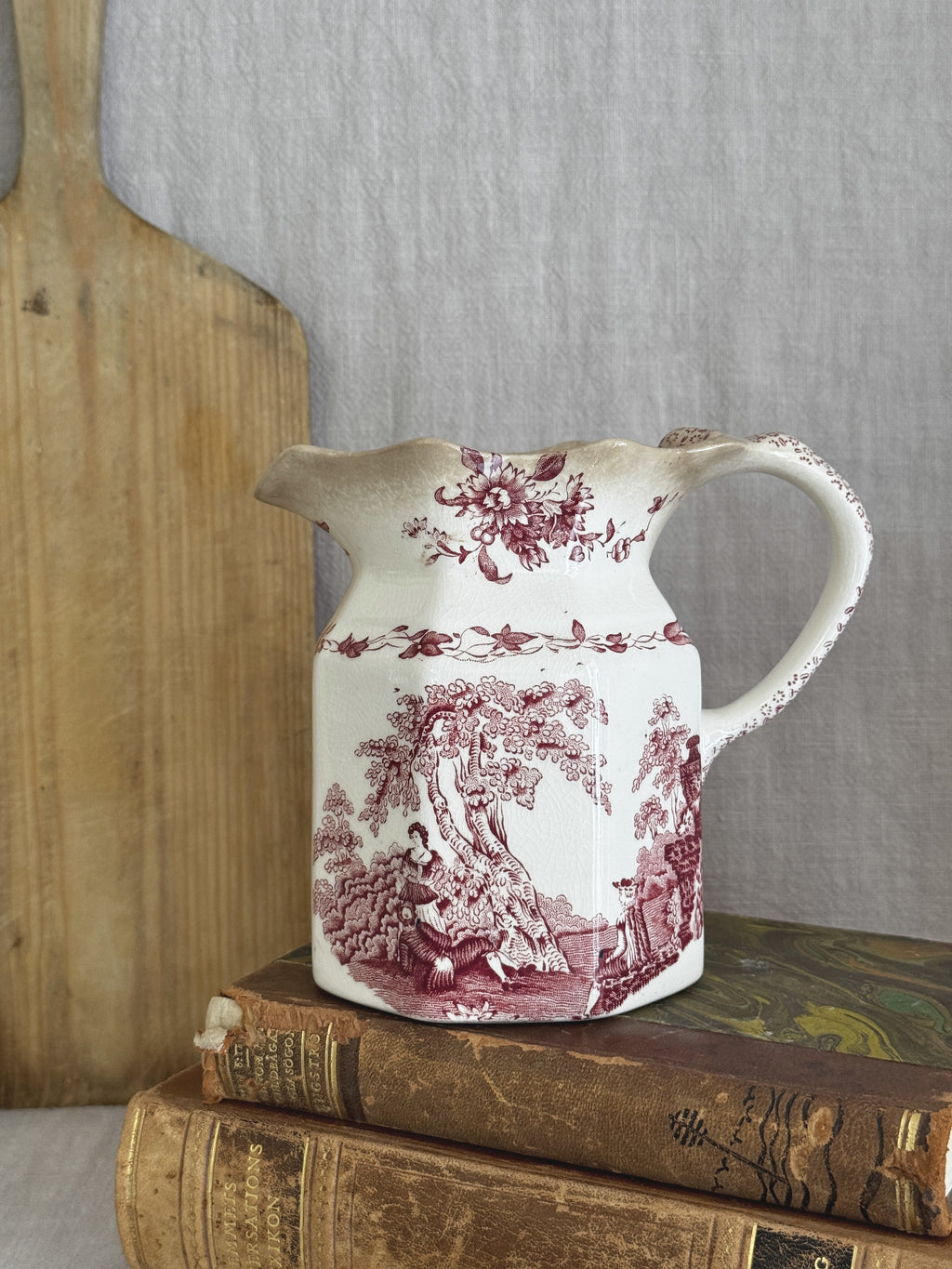 Vintage Masons Ironstone Watteau red transferware jug shown on a bread board and antique books for size reference