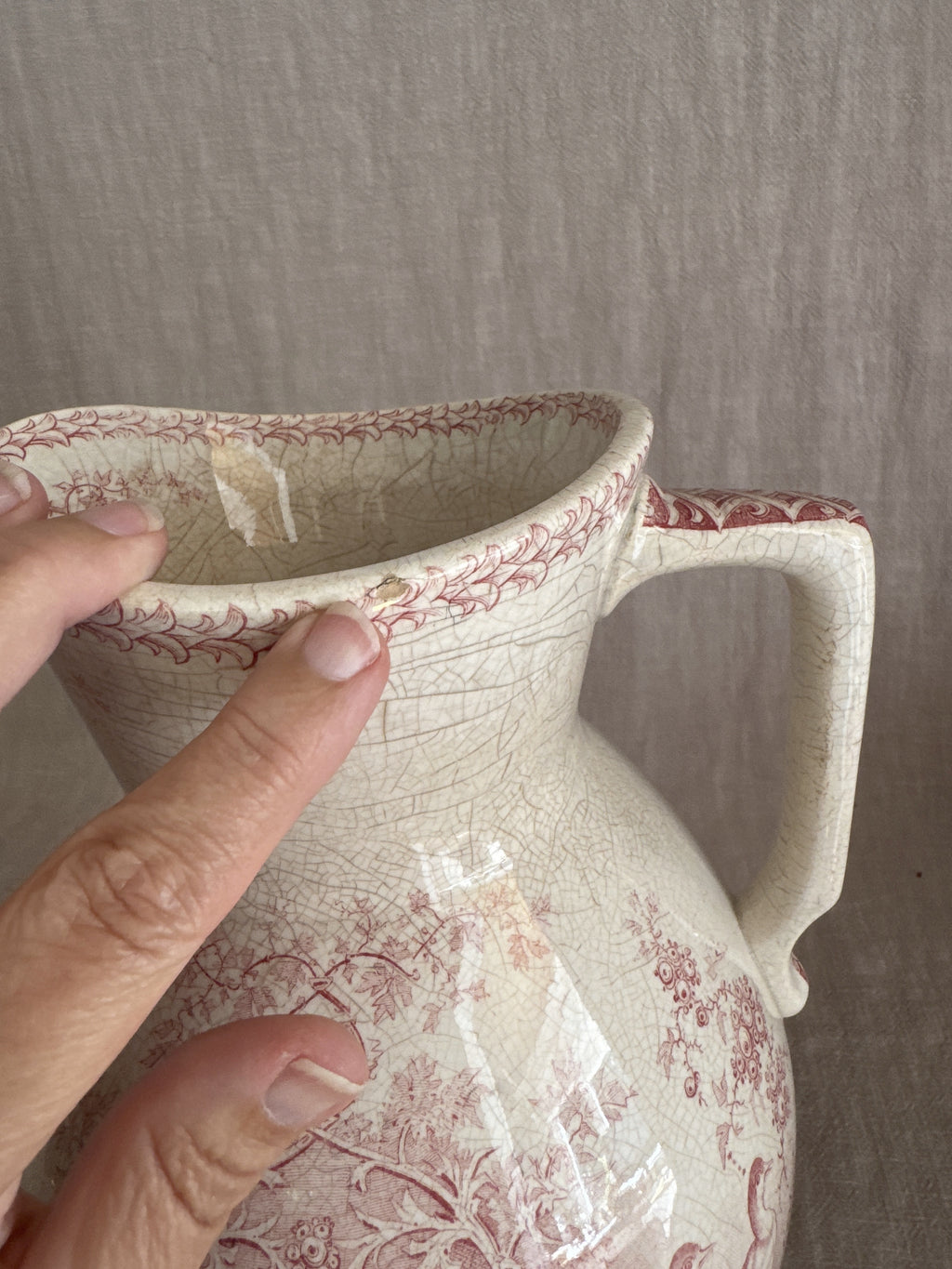 The spout of the jug held in hand, showing the transfer border and rim