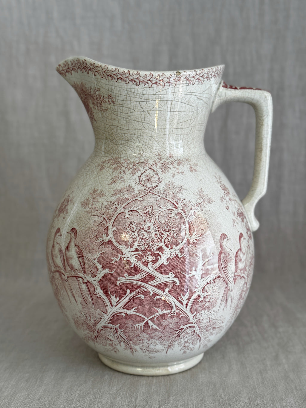 Front view of the Sarreguemines Colomba washstand jug showing the red transfer pattern and cream crazed glaze