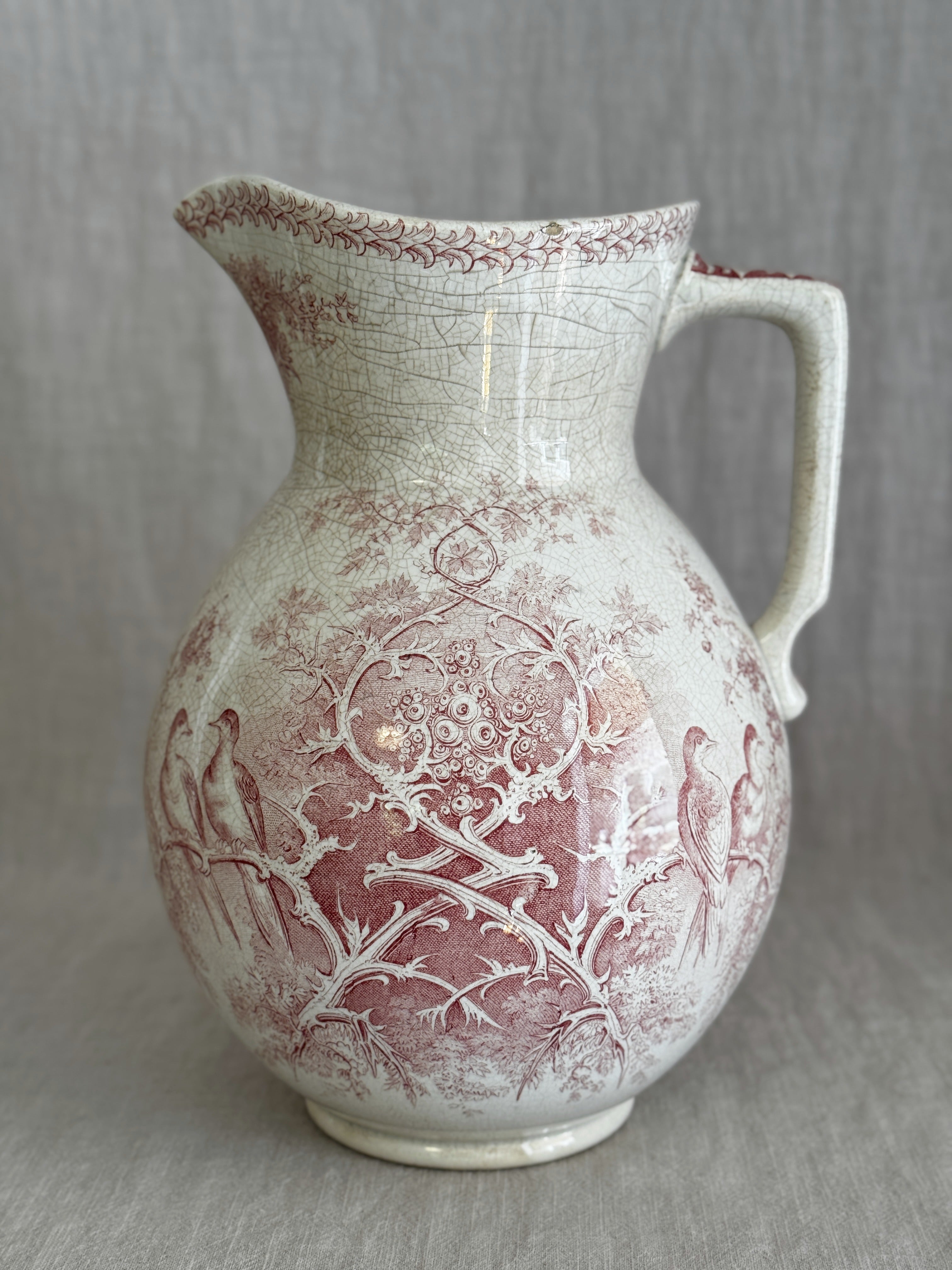 Front view of the Sarreguemines Colomba washstand jug showing the red transfer pattern and cream crazed glaze