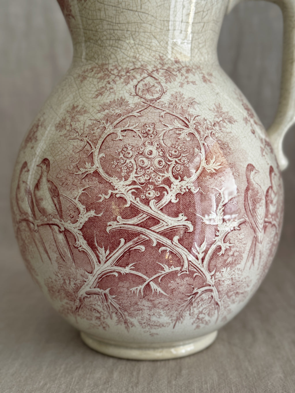 Close detail of the Colomba transfer pattern showing birds among branches on crazed cream faience