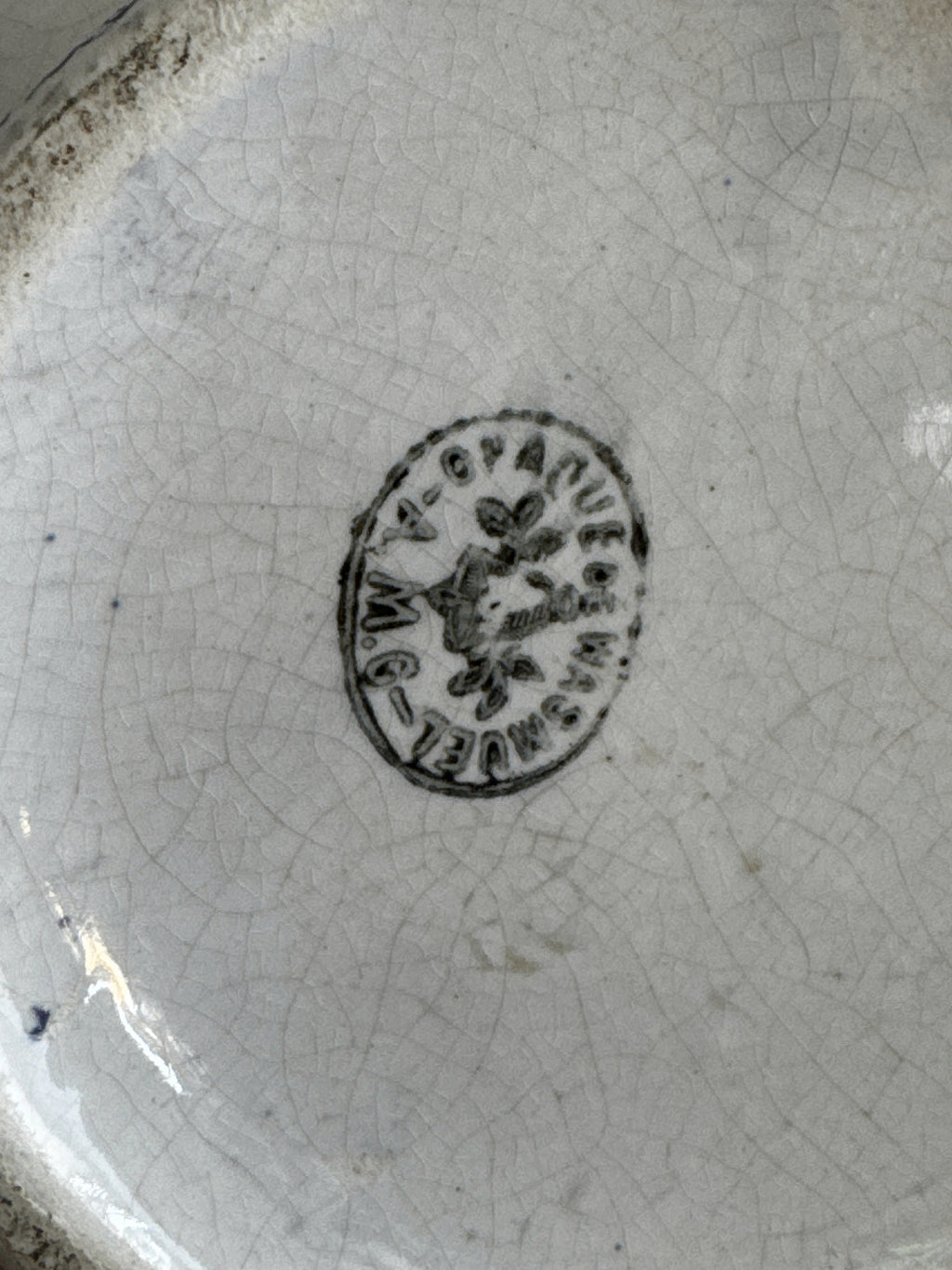 Base of the jug showing the round Opaque de Wasmuel mark with a flower at its centre