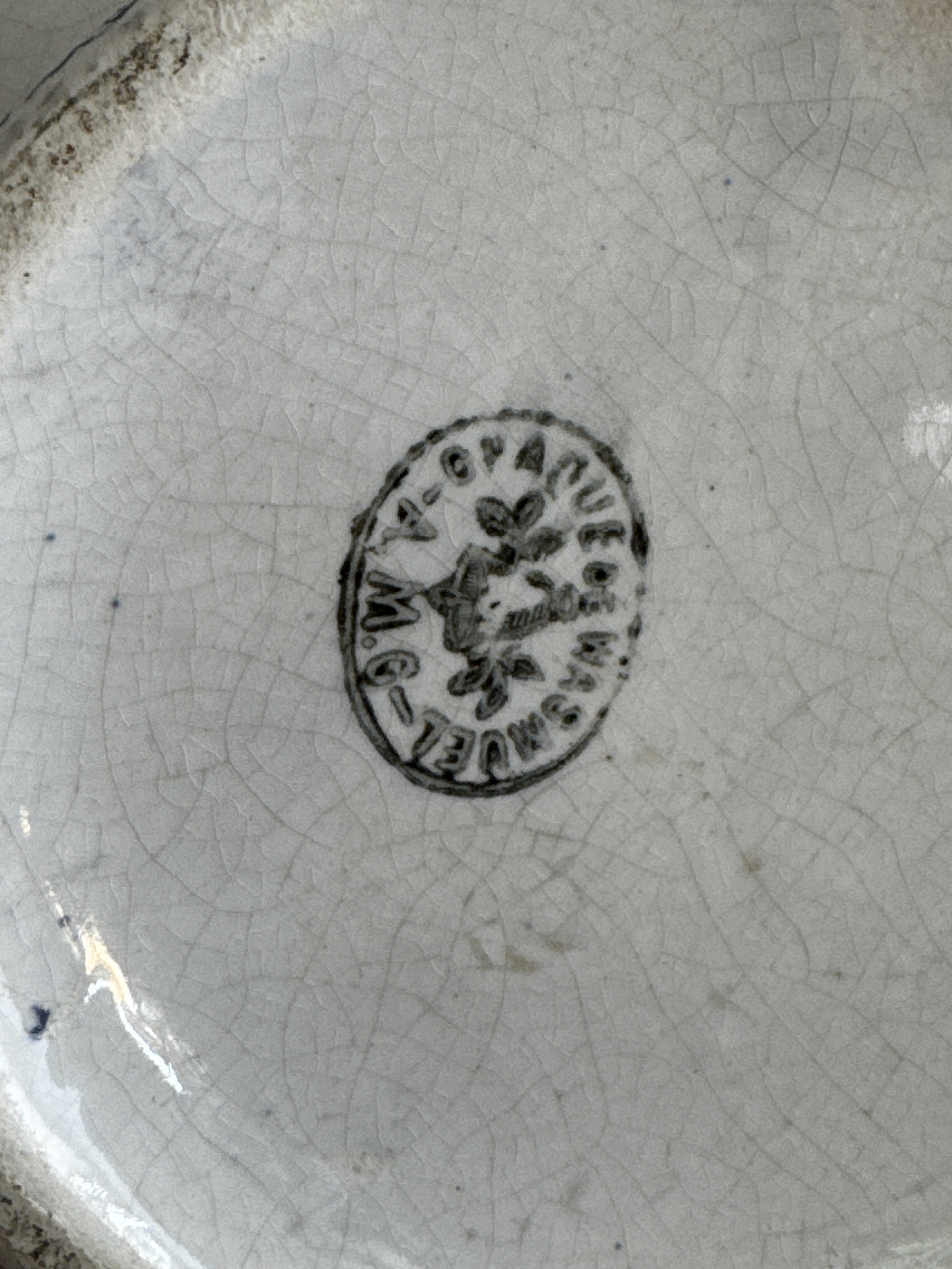 Base of the jug showing the round Opaque de Wasmuel mark with a flower at its centre