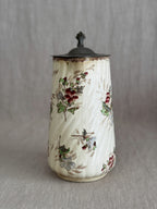 Full view of the jug with the pewter lid closed and the hand-coloured floral sprays visible
