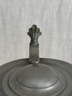 Detail of the pewter lid showing the moulded border and cast thumbpiece