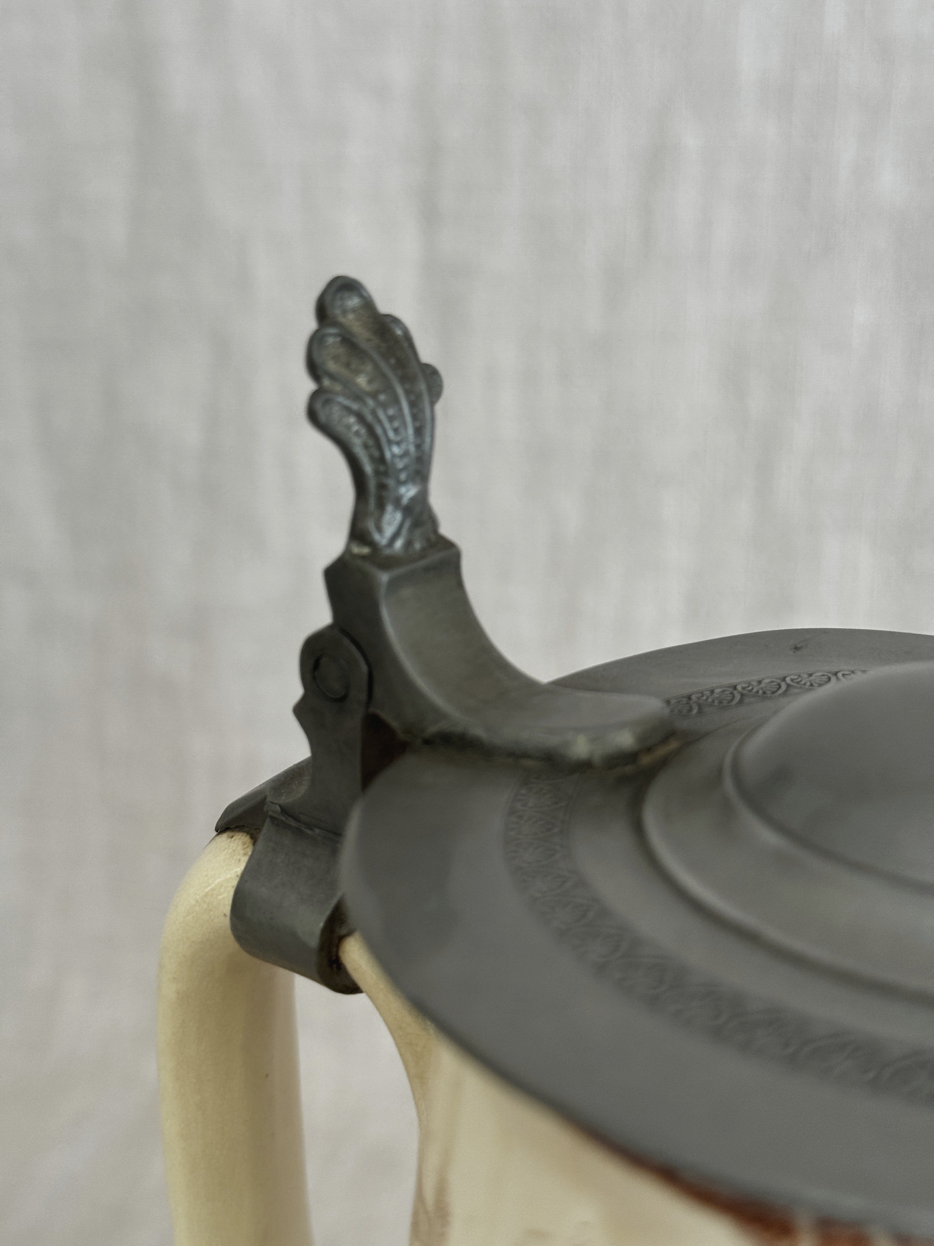 Close view of the pewter thumbpiece and hinge above the handle