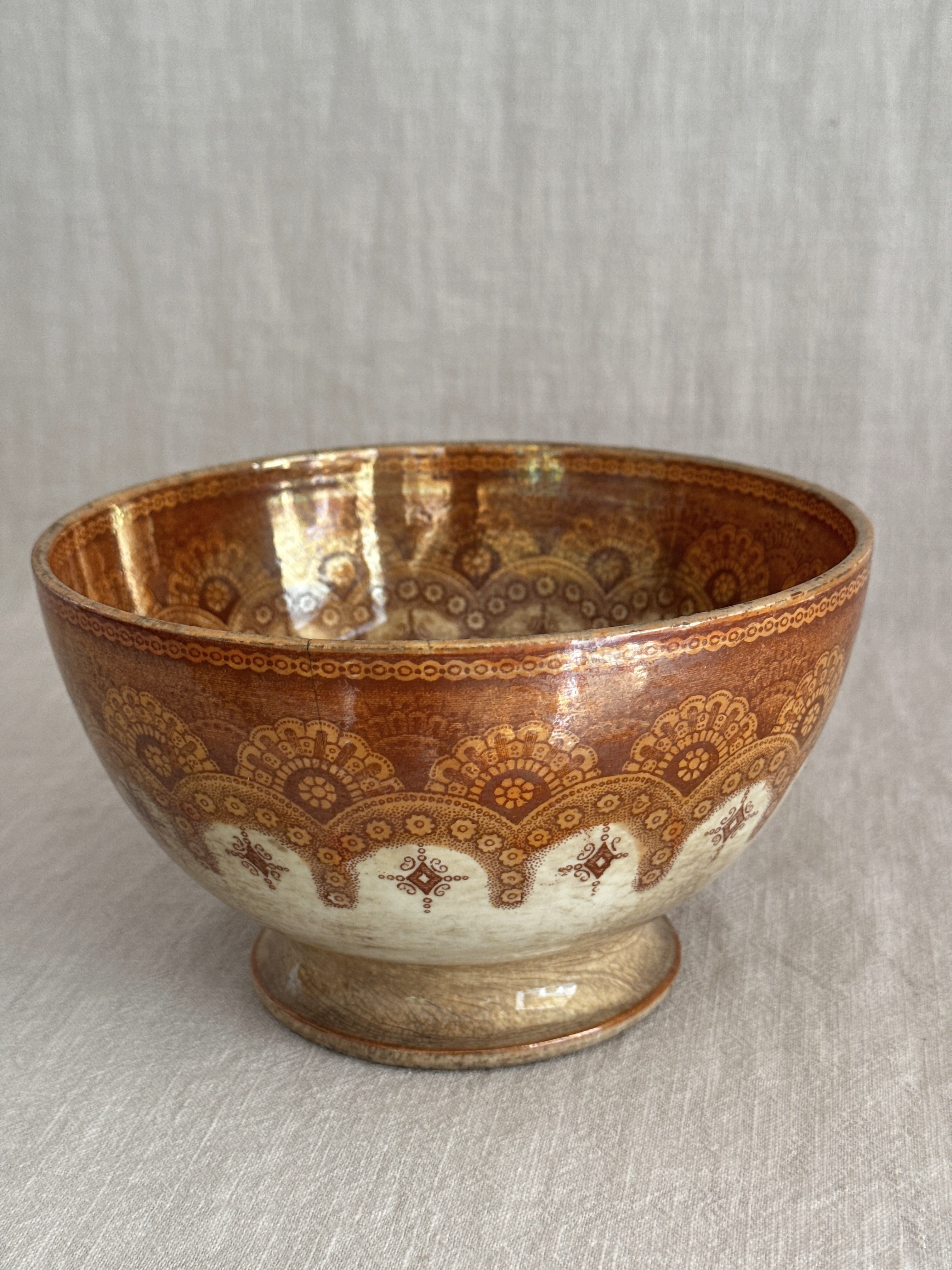 Close view of the printed border of rosettes and stars against the copper lustre glaze
