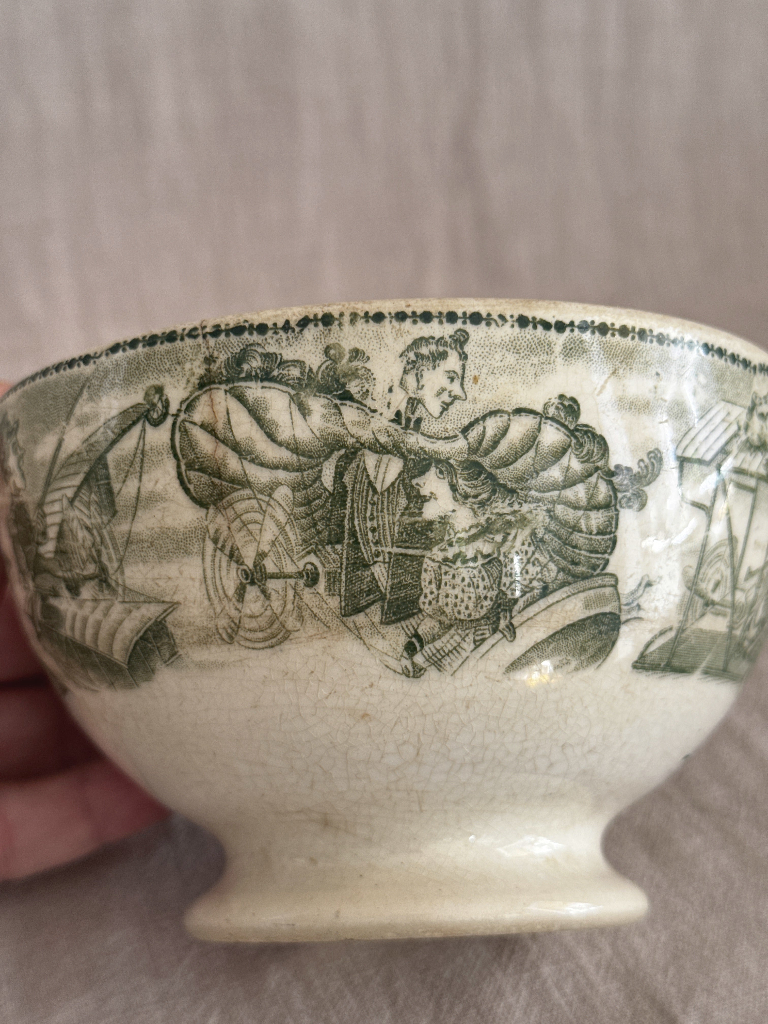 Side view of the green transferware bowl showing the aeroplane pattern and pedestal foot